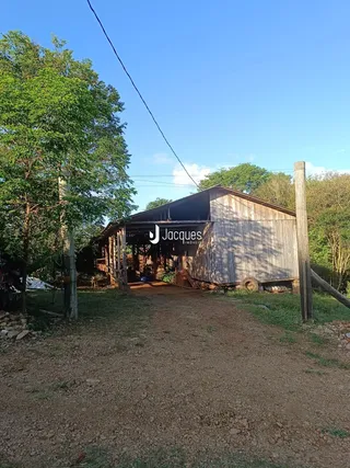 Vista da fachada de um celeiro de madeira em uma propriedade rural.