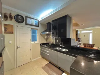 Vista da cozinha moderna com armários e bancadas escuras.