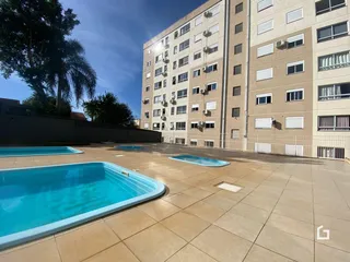 Vista de uma área externa com piscinas em um condomínio residencial.