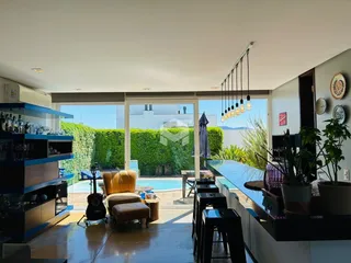 Sala de estar com vista para uma área externa com piscina e jardim.