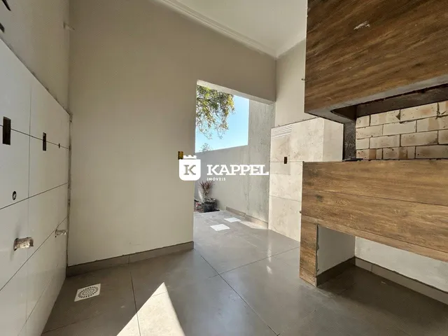 Hall de entrada com paredes brancas e piso de concreto em um imóvel.