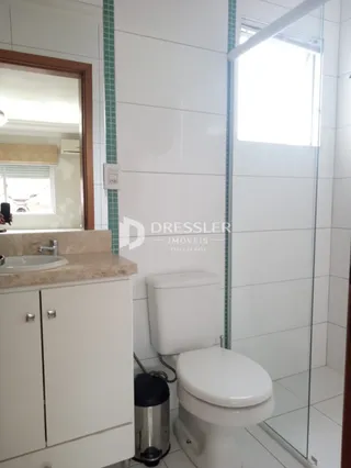 Foto de um banheiro com azulejos brancos e vaso sanitário.