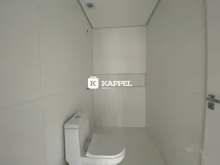 Banheiro branco com vaso sanitário e piso claro.