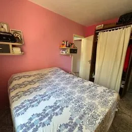 Quarto com cama coberta com estampa azul e branca.