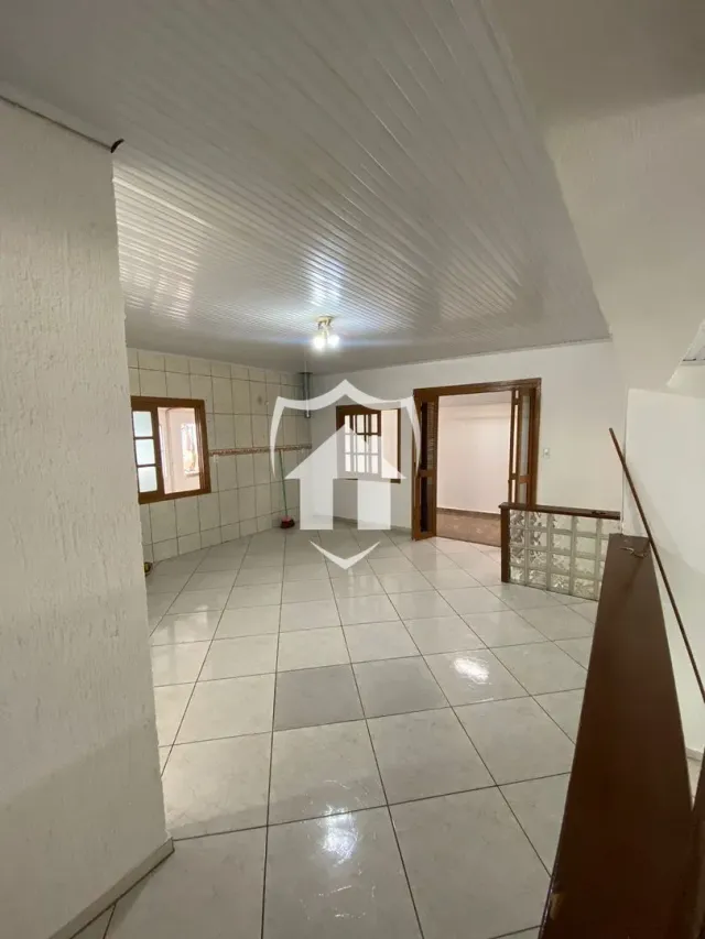 Corredor interno com piso de cerâmica e teto branco.