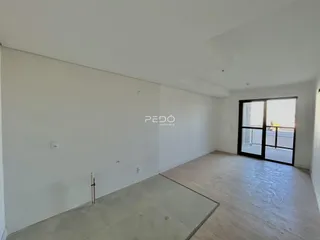 Ambiente interno de um imóvel com piso de madeira e paredes brancas.