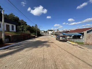 Vista da rua em Lajeado, Brasil, mostrando casas e uma estrada pavimentada.
