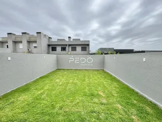 Fachada de um imóvel com jardim gramado na frente.