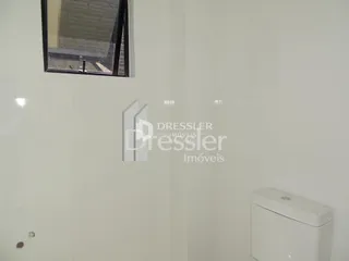 Foto de uma parede interna com um vaso sanitário.
