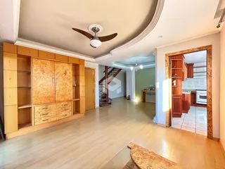 Ambiente interno de uma sala de estar com piso de madeira clara e armários embutidos.
