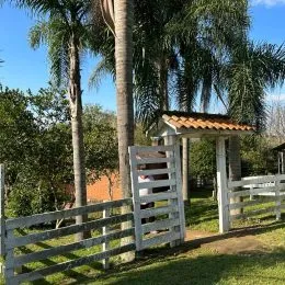 Cerca de madeira e vegetação em uma propriedade.