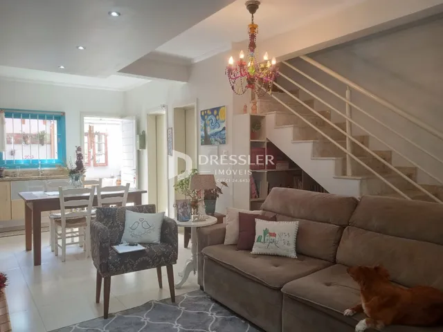 Sala de estar com sofá e escadaria em um imóvel no Brasil.