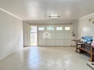 Sala de estar com piso de cerâmica e porta de garagem visível.