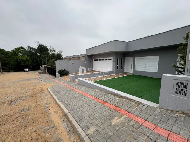 Fachada externa de uma residência em Lajeado, Brasil, com jardim e área pavimentada.