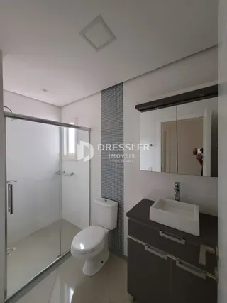 Banheiro moderno com box de vidro e revestimento de azulejo
