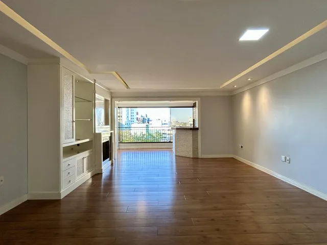 Sala de estar com piso de madeira e vista para o horizonte.