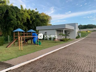 Fachada de uma casa com área de lazer e gramado.
