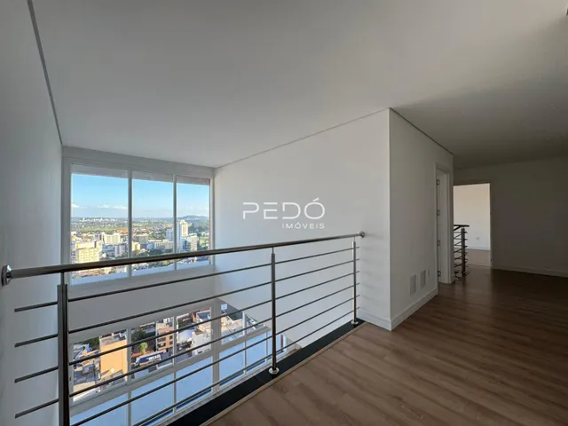 Vista de um ambiente interno com sacada e vista da cidade.