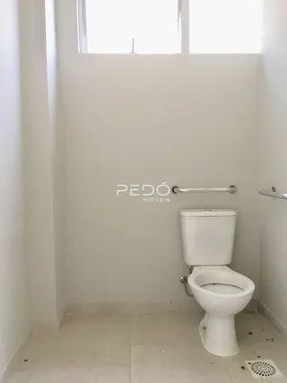Foto interna de um banheiro com vaso sanitário branco.