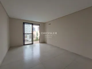 Ambiente interno de uma sala ampla com piso de cerâmica e porta de vidro.