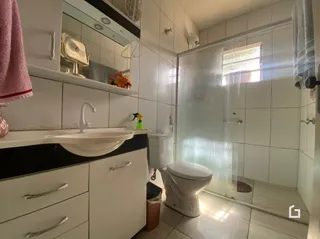 Foto de um banheiro interno com azulejos brancos e box de vidro.