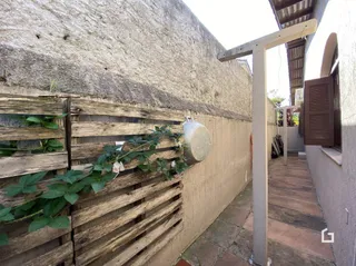 Vista externa de uma parede com tábuas de madeira e vegetação em Lajeado.