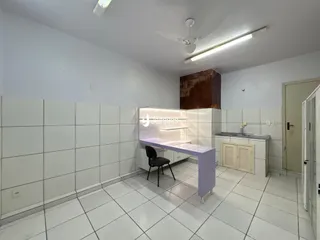 Interior de uma cozinha com revestimento cerâmico branco nas paredes e piso.