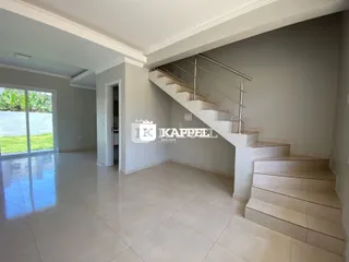 Foto do hall de entrada com piso de cerâmica e escadaria.