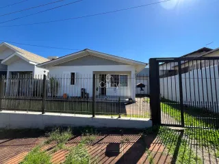 Fachada de uma residência branca em Lajeado, Brasil, com cerca de metal na frente.