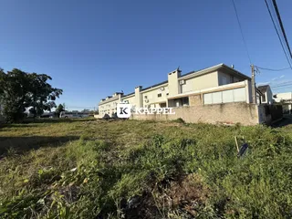 Vista externa de um complexo de edifícios em Lajeado, Brasil, com área de grama em primeiro plano.