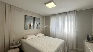Quarto com cama e cortinas brancas em um imóvel.