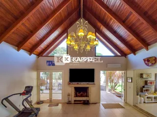 Sala de estar com pé direito alto e lareira em ambiente residencial.