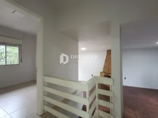 Corredor com escada que leva a uma sala com lareira.