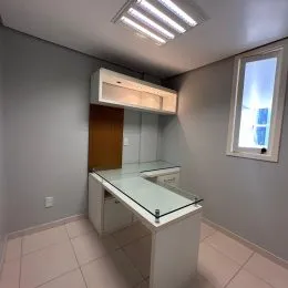 Foto de uma área de cozinha com bancada e janela em um imóvel.