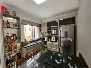 Uma cozinha com armários de madeira e janela em um imóvel no Brasil.