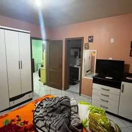 Foto interna de um cômodo com armário branco e sofá.