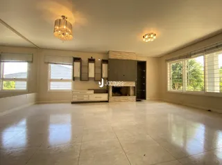 Sala de estar ampla com piso claro e muita luz natural.