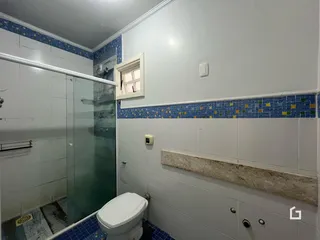 Um banheiro com revestimento cerâmico azul e branco.