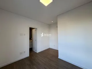 Ambiente interno com piso de madeira clara e paredes brancas.