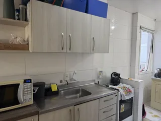Foto de uma cozinha com bancada e eletrodomésticos instalados.