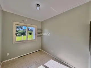 Vista interna de uma sala com paredes cinzas e piso de cerâmica.