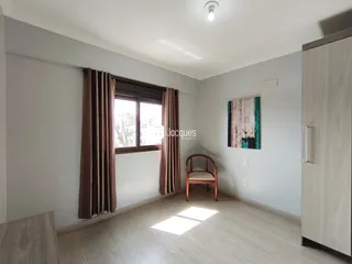 Sala de estar com janela e cortinas em um imóvel no Brasil.