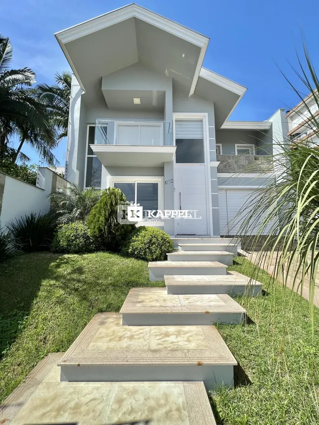 Vista externa de uma casa moderna em Lajeado com jardim e escadaria de pedra.