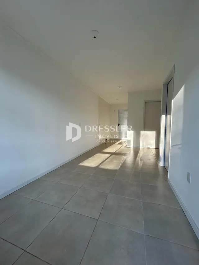 Corredor interno com piso de cerâmica claro em uma propriedade.