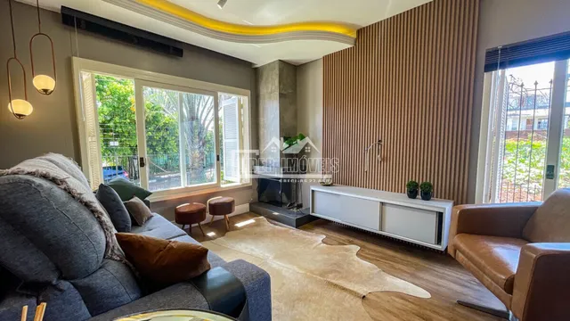 Sala de estar com piso de madeira e lareira em um imóvel no Brasil.