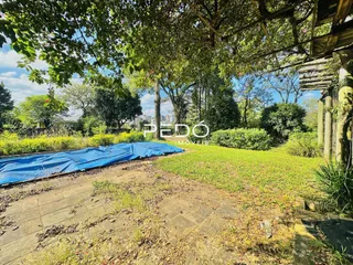 Vista externa de um jardim com grama e uma cobertura de lona.