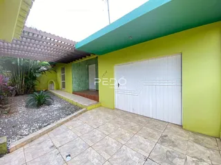 Fachada externa de uma residência em Lajeado, Brasil, com garagem branca e revestimento verde.