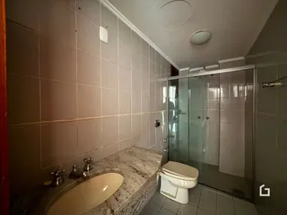 Foto de um banheiro com revestimento cerâmico e bancada de mármore.