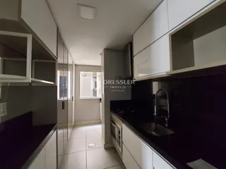 Vista de um corredor interno com armários e piso claro.