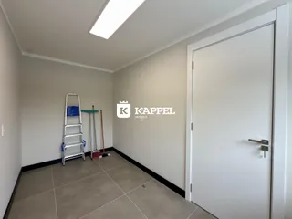 Hall de entrada com paredes brancas e piso de porcelanato claro.